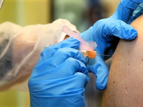 A pharmacist administers a flu shot in this file photo. Seniors in Sudbury who haven't yet been able to obtain a higher-dose flu shot are being advised to accept a standard version rather than wait on an unpredictable supply.