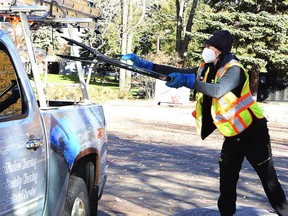 Josee Legault, of Reliable Cleaning Services, removes debris from an encampment at Memorial Park on Nov. 4.