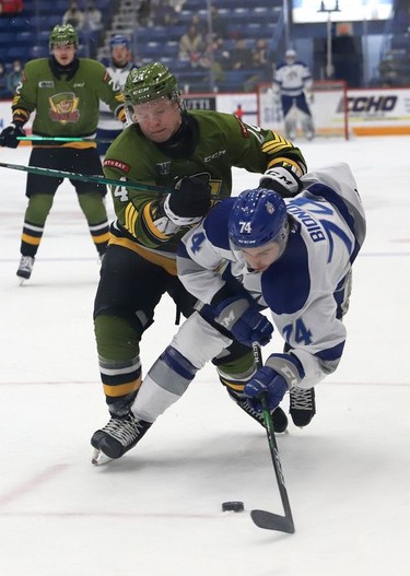 Giordano Biondi, front, of the Sudbury Wolves, and Ty Nelson, of the North Bay Battalion, battle for the puck during OHL action at the Sudbury Community Arena in Sudbury, Ont. on Friday November 12, 2021. John Lappa/Sudbury Star/Postmedia Network