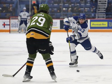 Liam Ross, right, of the Sudbury Wolves, fires the puck past Nic Sima, of the North Bay Battalion, during OHL action at the Sudbury Community Arena in Sudbury, Ont. on Friday November 12, 2021. John Lappa/Sudbury Star/Postmedia Network