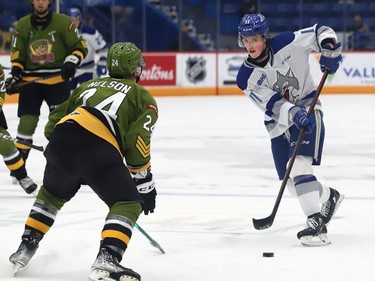 Landon McCallum, right, of the Sudbury Wolves, passes the puck to a teammate as Ty Nelson, of the North Bay Battalion, keeps an eye on the play during OHL action at the Sudbury Community Arena in Sudbury, Ont. on Friday November 12, 2021. John Lappa/Sudbury Star/Postmedia Network