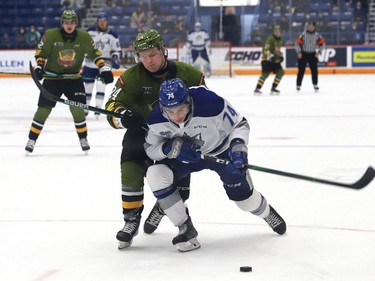 Giordano Biondi, front, of the Sudbury Wolves, and Ty Nelson, of the North Bay Battalion, battle for the puck during OHL action at the Sudbury Community Arena in Sudbury, Ont. on Friday November 12, 2021. John Lappa/Sudbury Star/Postmedia Network