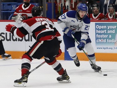 Quentin Musty, right, of the Sudbury Wolves, attempts to elude Teddy Sawyer, of the Ottawa 67's, during OHL action at the Sudbury Community Arena in Sudbury, Ont. on Friday November 19, 2021. John Lappa/Sudbury Star/Postmedia Network