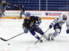 Sudbury Wolves defenceman Jack Thompson (22) plays a puck under pressure from Mississauga Steelheads forward Aidan Prueter during first-period OHL action at Sudbury Community Arena in Sudbury, Ontario on Thursday, November 25, 2021. Ben Leeson/The Sudbury Star/Postmedia Network