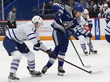 Quentin Musty, right, of the Sudbury Wolves, is tripped up by Kai Schwindt, of the Mississauga Steelheads, during OHL action at the Sudbury Community Arena in Sudbury, Ont. on Friday November 26, 2021. John Lappa/Sudbury Star/Postmedia Network