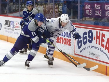 Landon McCallum, left, of the Sudbury Wolves, and Evan Brand, of the Mississauga Steelheads, battle for possession of the puck during OHL action at the Sudbury Community Arena in Sudbury, Ont. on Friday November 26, 2021. John Lappa/Sudbury Star/Postmedia Network