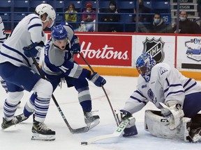 Landon McCallum, middle, of the Sudbury Wolves, looks for a rebound in front of goalie Roman Basran, of the Mississauga Steelheads, during OHL action at the Sudbury Community Arena in Sudbury, Ont. on Friday November 26, 2021. John Lappa/Sudbury Star/Postmedia Network