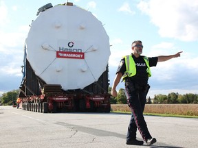 Sarnia Const. Giovanni Sottosanti (left) directs traffic Sept. 25 at Blackwell Side Road and Confederation Line, as a piece of equipment bound for Shell's Corunna refinery waits to turn. Extra pavement was added to the corner earlier this year, and officially approved by Sarnia city council Oct. 25, to make the turn easier for oversized loads like the 287-tonnne and 10-metre high vessel that made its way from Sarnia's harbour. Tyler Kula/Postmedia