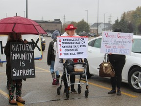 Protesters are shown in the Lambton Mall parking lot on Oct. 29 during a stop in Sarnia by the GO-VAXX mobile immunization clinic. The converted GO-Transit bus has been travelling Ontario helping to administer COVID-19 vaccinations. Paul Morden/Postmedia