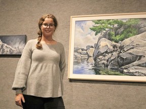 Ryleigh Belec, an attendant at the Timmins Museum, displays some of works by artist Martin Foley that are featured in latest exhibition entitled "A Northern Perspective." It will be showing in the museum's Grey Gallery until Dec. 5.

ANDREW AUTIO/The Daily Press