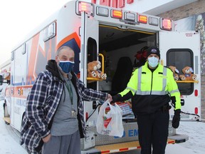 Sylvain Lacroix, left, was among those who dropped by to contribute to the 10th-annual Fill An Ambulance toy drive held on Saturday. Accepting his donation here is Derrick Cremin, commander of Cochrane District EMS.

RON GRECH/The Daily Press