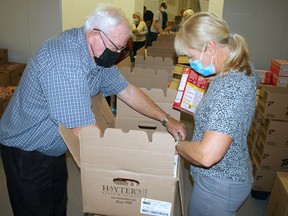 Rick McGregor and Vicki Snowsell are two of 15 volunteers packing hampers Thursday for Christmas Care at Elgin Centre shopping mall. Deadline for registration is Dec. 7.
Eric Bunnell