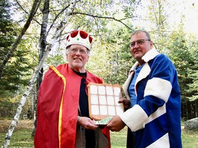 A humble lackey presents Phil Burke with the annual Great Canadian Whiskeyjack Calling Contest winner’s plaque and cash.