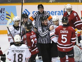 Linesman Kevin McArthur instructs Stepan Machacek to settle down during a post-whistle scrum in front of Storm goaltender Jacob Oster in the first period as the Owen Sound Attack host the Guelph Storm inside the Harry Lumley Bayshore Community Centre Saturday, Nov. 13, 2021. Greg Cowan/The Sun Times