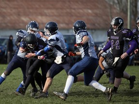 OSDSS quarterback Jack Kivell is swarmed by the St. Mary's Mustangs defence as the two teams play in the first quarter of the Bluewater Athletic Association football championship Friday at Victoria Park in Owen Sound. Ben Duwyn (No. 14 for St. Mary's) won the Georgian Bay Football Officials Association award as the Mustangs topped the Wolves 9-0 to win a seventh-straight BAA title.Greg Cowan/The Sun Times