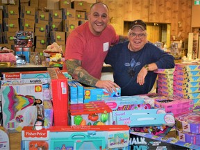 Ryan Turcotte, left, chair of the Belleville Professional Firefighters' Toy Drive, and volunteer George Fisher have worked since early November to pack 1,500 goodwill boxes with toys, games and clothing to brighten Christmas day for less-fortunate children across the city. DEREK BALDWIN