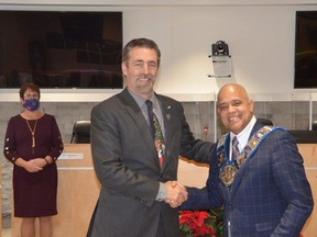 Selwyn Hicks, right, is congratulated by 2020 Grey County Warden Paul McQueen after he was chosen as warden for the 2022 term. Hicks, who is returning to the position for the second year in a row and third time in four years, defeated challenger Christine Robinson. A vote of council resulted in a 9-9 tie, and to break the tie, chief administrative officer Kim Wingrove drew Hicks' name from a box. Looking on is Grey County clerk Heather Morrison.
