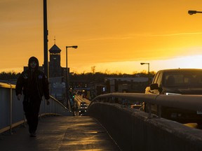A pedestrian walks over the Dundas St E bridge above the Trent river as the sun sets. ALEX FILIPE