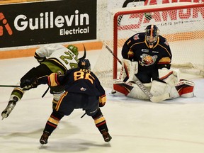 Ty Nelson of the North Bay Battalion drives to the net to test Mack Guzda of the visiting Barrie Colts in Ontario Hockey League action Sunday as Beau Akey tries to help his goaltender. The Troops host the Niagara IceDogs on Thursday night.
Sean Ryan Photo