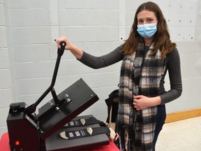 Kaylee Lantz of Finely Paired uses a heat press to make her printed socks during the Student Makers Market at the Sydenham Campus in Owen Sound on Saturday, December 11, 2021.