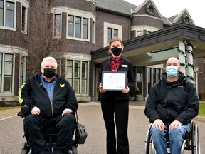 The Bruce Hotel was named the winner of the Stratford accessibility advisory committee's 2021 Accessibility Award. Pictured, committee chair Pete Zein (left) and committee member Roger Koert (right) present hotel general manager Jennifer Belanger with the award certificate in front of The Bruce Hotel Wednesday afternoon. (Galen Simmons/The Beacon Herald)