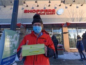 Steve Mole holds a COVID -19 antigen test kit that he picked up at the Shoppers Drug Mart in Calgary on Friday, Dec. 17, 2021. The lineup continued inside the store and it takes an average of one hour for each person to get a kit.