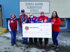 Diane Ruediger, Gordon Seller, Danial Claypool, Lyle Gustafson (left to right) of the Devon Lions Club presented Jill Spisak of the Robina Baker Elementary School's parent committee representative with a $10,604.54 to build a new playground for kids. Kajal Dhaneshwari