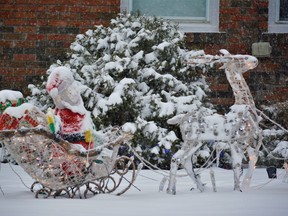 Santa and his reindeer were dusted in snow at a home display in Belleville during Saturday's snow storm. DEREK BALDWIN