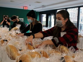 Nipissing University business student Alex Arnott takes a few pictures as Nico Waltenbury, Jessica Couch and Taylor Hummel check some of the 750 Bay Bundles being packed, Saturday, at St. Joseph-Scollard Hall.
PJ Wilson/The Nugget