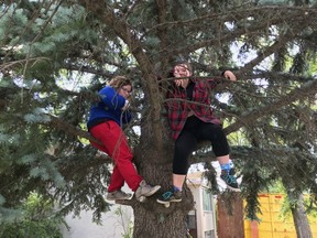 Jenny Winkler, left, and best friend Erika Williams, hanging out in the giant tree at 4517 52 St., which was lit up in Winkler’s memory, on December 23, 2021. (Louise Molenkamp)