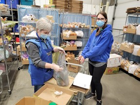 Brenda Hines and Megan Suthlerland prepare an order for the Leduc Food Bank’s Bread Basket program, December 16, 2021. (Dillon Giancola)