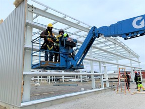A new retail complex with a floor area of more than 12,000 square feet is under construction at the site of the former Roxburgh’s Country Market at the intersection of Highway 3 and Blue Line Road east of Simcoe. In the skyjack are Greg Wilson, left, and Jason Grant of Pressey Construction of Vienna. – Monte Sonnenberg