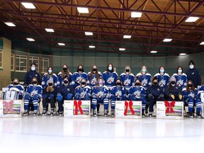 Players and staff from the Sudbury Lady Wolves U18 AA team pose for a team photo with five TVs they donated to the NEO Kids Foundation, using money formerly set aside for the team Christmas party.
