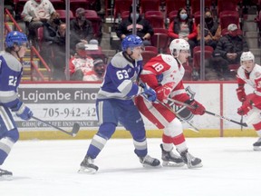 Soo Greyhounds forward Bryce McConnell-Barker and Sudbury Wolves defenceman Liam Ross battle for position in the Wolves zone during first period action at the GFL Memorial Gardens on Wednesday night. The Hounds picked up a 5-4 overtime win over the Wolves.