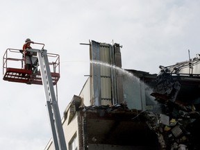 A worker pours water to prevent the spread of dust as the demolition of the former St. Vincent de Paul Hospital continues on Aug. 9. (RONALD ZAJAC/The Recorder and Times)