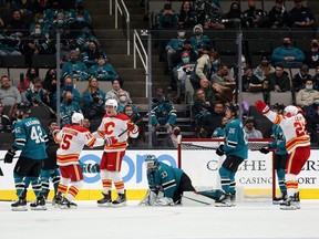 Adam Ruzicka (63) of the Calgary Flames is congratulated by Brad Richardson (15) after he scored his first goal of the season on Adin Hill (33) of the San Jose Sharks in the second period at SAP Center on December 07, 2021, in San Jose, California. (Photo by Ezra Shaw/Getty Images)