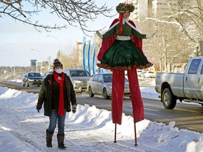 Liz Hobbs, right, dressed as a Christmas fairy, and Marian Brant, left, carefully walk on a snow covered sidewalk on 100 Avenue near Grant Notley Park on Sunday, Dec. 19, 2021, where Edmonton's first Winter Promenade, presented by the Silver Skate Festival Society, was held on Victoria Promenade.