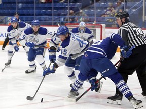 Sudbury Wolves forward Ethan Larmand (45) battles for the puck after a faceoff with Mississauga Steelheads forward Luca DelBelBelluz (73) during first-period OHL action at Sudbury Community Arena in Sudbury, Ontario on Friday, December 31, 2021.