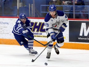 Sudbury Wolves defenceman Payton Robinson (49) carries the puck while Mississauga Steelheads forward Michael Stubbs (18) pursues during first-period OHL action at Sudbury Community Arena in Sudbury, Ontario on Friday, December 31, 2021.