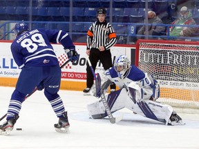 Sudbury Wolves goalie Mitchell Weeks (70) prepares to make a save on Mississauga Steelheads forward Ty Anselmini (89) during first-period OHL action at Sudbury Community Arena in Sudbury, Ontario on Friday, December 31, 2021.