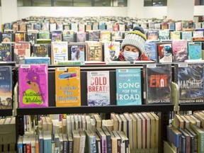 April Bos looks for a good book to read at the London Public Library Central branch in London on Wednesday, Dec. 8, 2021. Visits to London library branches in October were one-third of the number of visits in October 2019. (Derek Ruttan/The London Free Press)