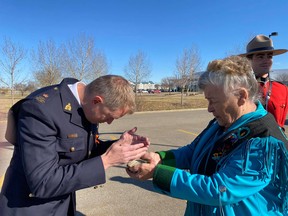 Insp. Mike McCauley accepts a smudge from Elder Kookum Doreen Wabesca outside of the Fort Saskatchewan RCMP detachment. Photo supplied.