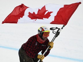 Canadian skier Manuel Osborne-Paradis carries the flag of Canada as he celebrates his retirement run before the start of the Audi FIS Ski World Cup Mens 2021 downhill skiing championship race at Lake Louise Ski Resort in Alberta, Canada on November 27, 2021.