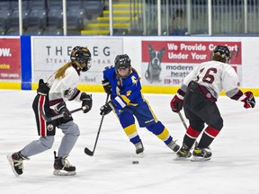 Sophie Carson (centre) of the BCI Mustangs navigates between a pair of Pauline Johnson Thuderbirds players during a high school girls hockey game on Wednesday at the Wayne Gretzky Sports Centre in Brantford.