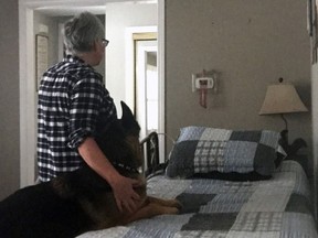 "Jean" and her dog look at the hospital bed used by her husband in their home for years before inconsistencies in home care forced her to place him in a long-term care home.