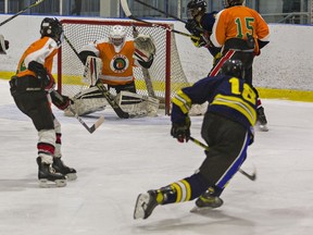 MacKinnon Park's Rowan Kays watches his shot head for the crossbar behind North Park goalie Carter Edwards during a high school boys hockey game  on Tuesday  at the Wayne Gretzky Sports Centre in Brantford.