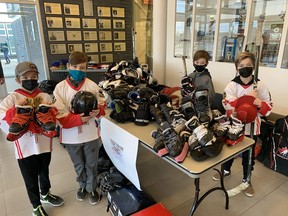 Sean Baxter (left), LIam Devries, Xavier Cormier and James Baxter, of the U-11 Paris Wolfpack, pose with some of the hockey equipment collected by the hockey team at the Brant Sports Complex on Saturday. The equipment drive has held in conjunction with Rotary International. Plans call for the equipment to be delivered to remote Indigenous communities where hockey can be prohibitively expensive.