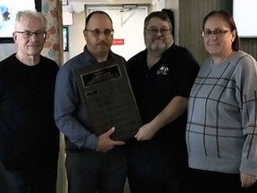 Brian Vickerman (left) and Matt Welsh of the Brantford Football Officials Association present the Robert Welsh Memorial Award to Rob and Jen Dallaway. Submitted