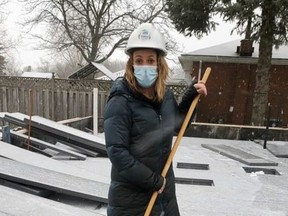 Kayla Ripley clears snow at 28 Willowdale St. in Brant County as work on her Habitat home continues. Ripley and her three children will be moving into the home in the spring.