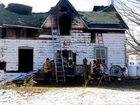 Officials remove debris and a child's toy from the scene of a fatal house fire near Westport on Wednesday afternoon.